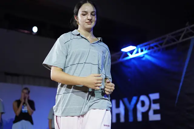 Smiling dancer in a shirt in front of the HYPE banner