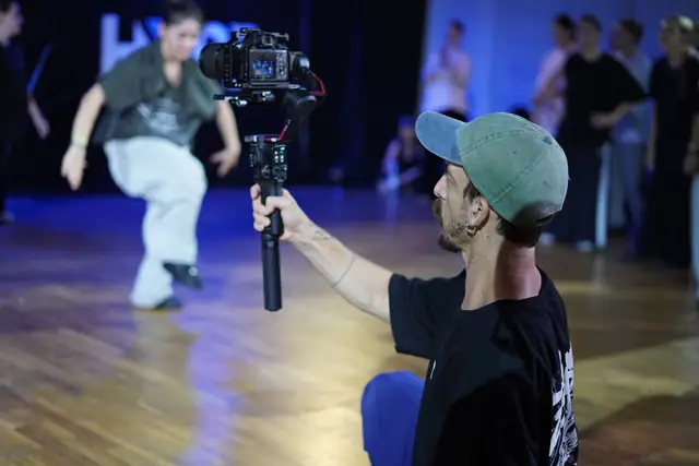Behind the scenes: a videographer with a gimbal filming a dancer