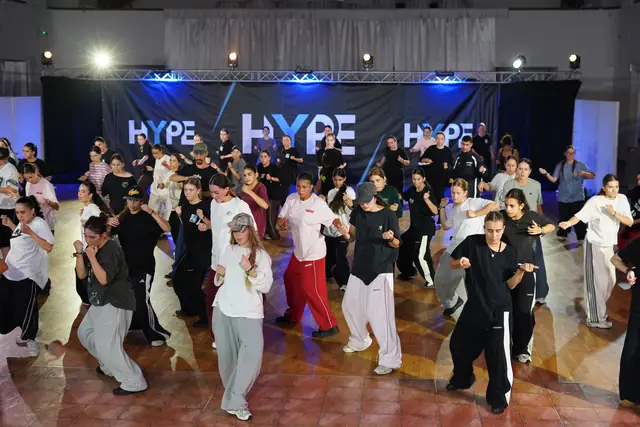 Plná lekcia tancuje spolu pred bannerom HYPE