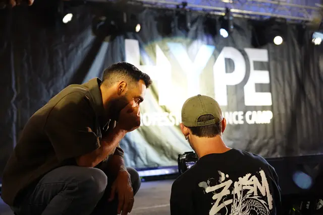 Two people laughing together near the HYPE banner