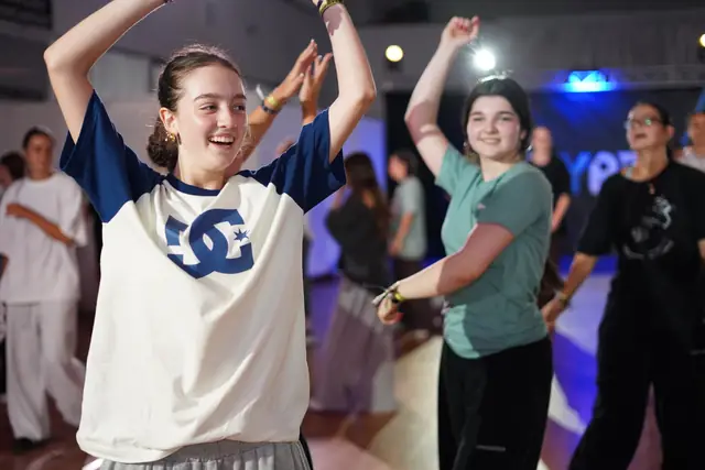Students smiling and cheering while dancing in a class