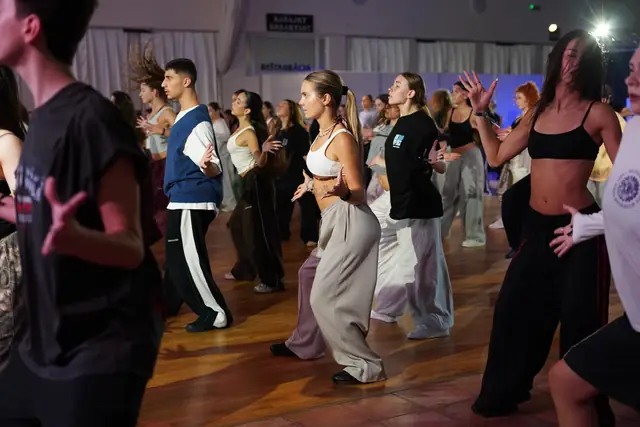 Tanečníci tancujú tesne vedľa seba počas lekcie